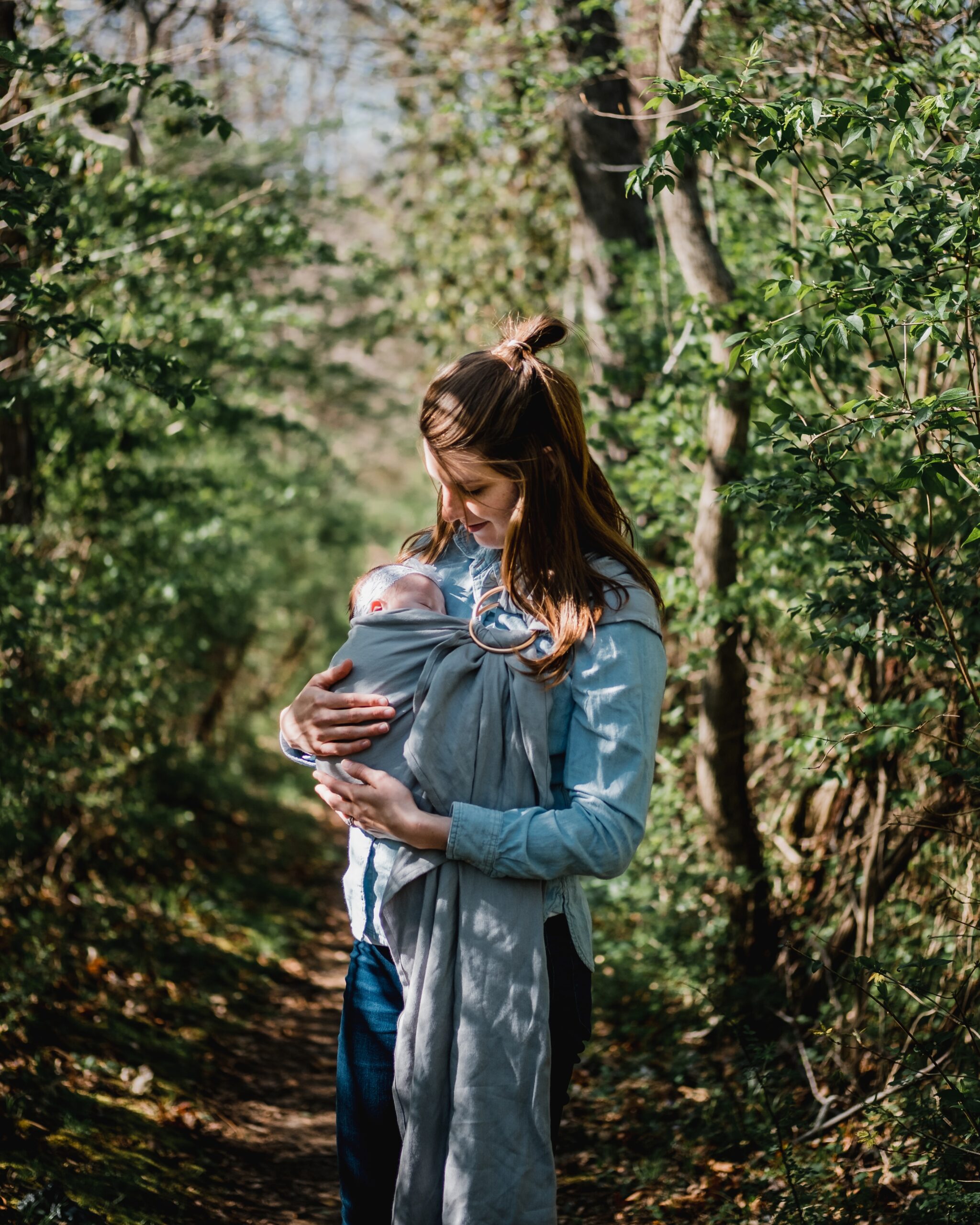 woman cradles baby in sling
